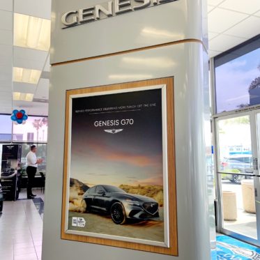 Genesis column with large format posters at dealership